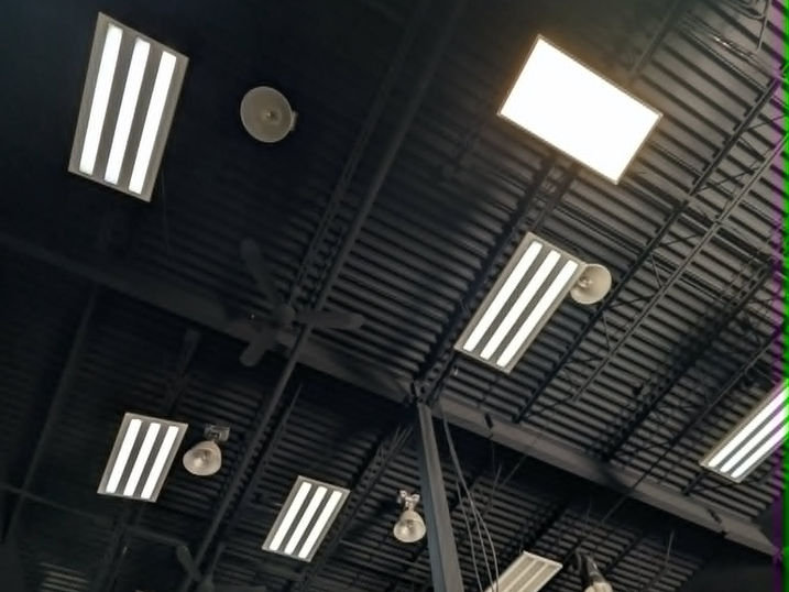 Black painted exposed ceiling at Wellspring Studios in Nepean, Ontario, showing painted beams, ductwork, structural deck, lighting fixtures, ceiling fans and industrial warehouse details.