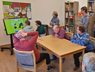 Menschen sitzen am Aktivtisch, andere schauen zu