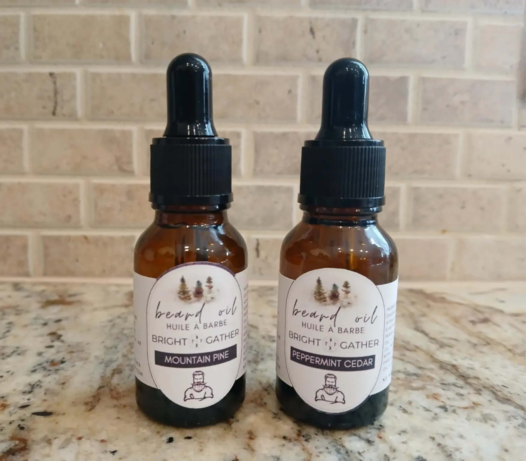Two beard oils are standing next to eachother on a countertop. One beard oil is Peppermint Cedar - the other is Mountain Pine