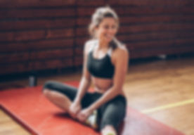 Althetic Woman Stretching On A Gym Mat