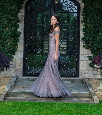 woman in off the shoulder lace gown twirling in fancy doorway