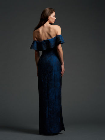 back view of woman in off the shoulder teal brocade gown with beaded flounce
