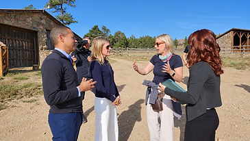 Libby Barnes and Leon speaking with the Ranchland Listings production team outdoors at a Colorado ranch property.