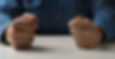Angry looking clenched fists on a tabletop
