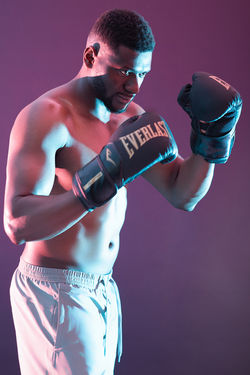 Boxer in stance, Everlast gloves, dynamic studio shot. Sports training.