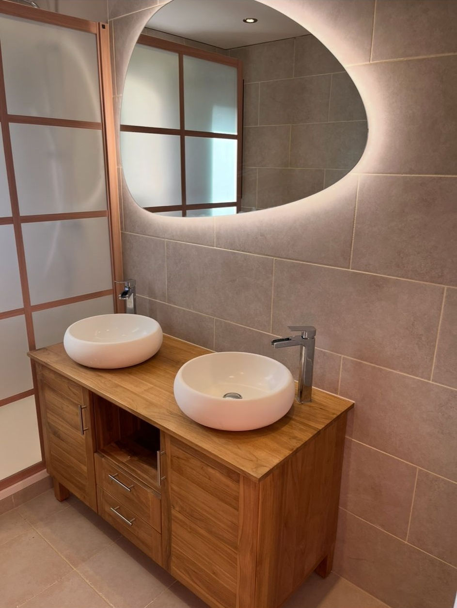 Meuble double vasque en bois clair et miroir rond, installation sanitaire réalisée par Kyan Plomberie Rénovation.