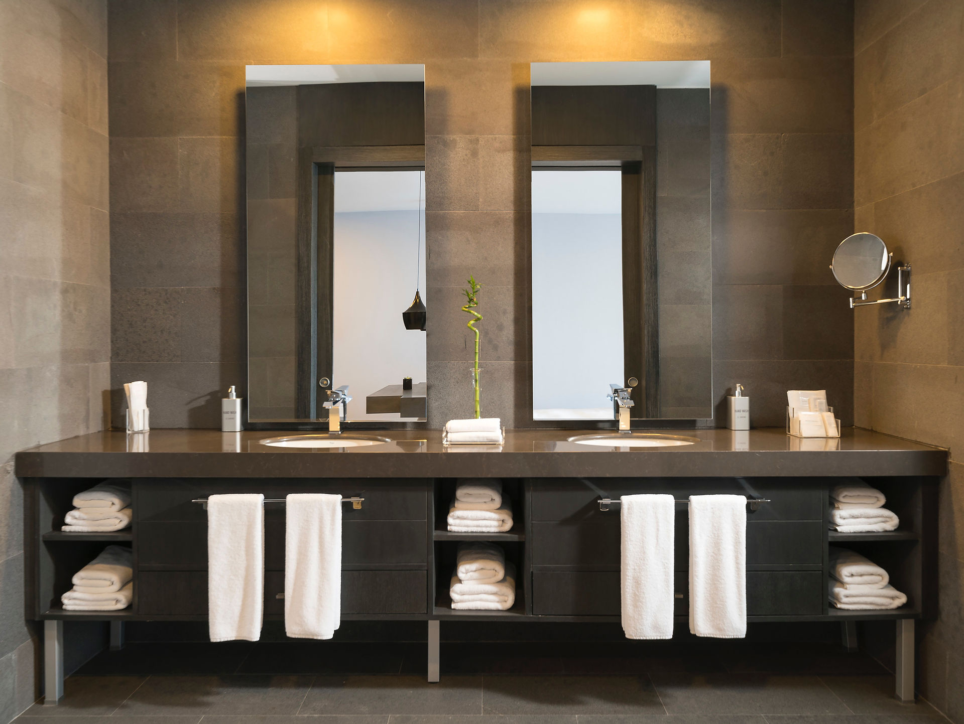 stunning interior photography of a bathroom with towels and mirror and well lit up
