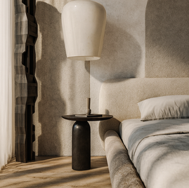 Serene minimalist villa suite bedroom featuring a textured curved headboard, oversized sculptural pendant light, and soft natural sunlight casting shadows on plaster walls by Velora Interior.