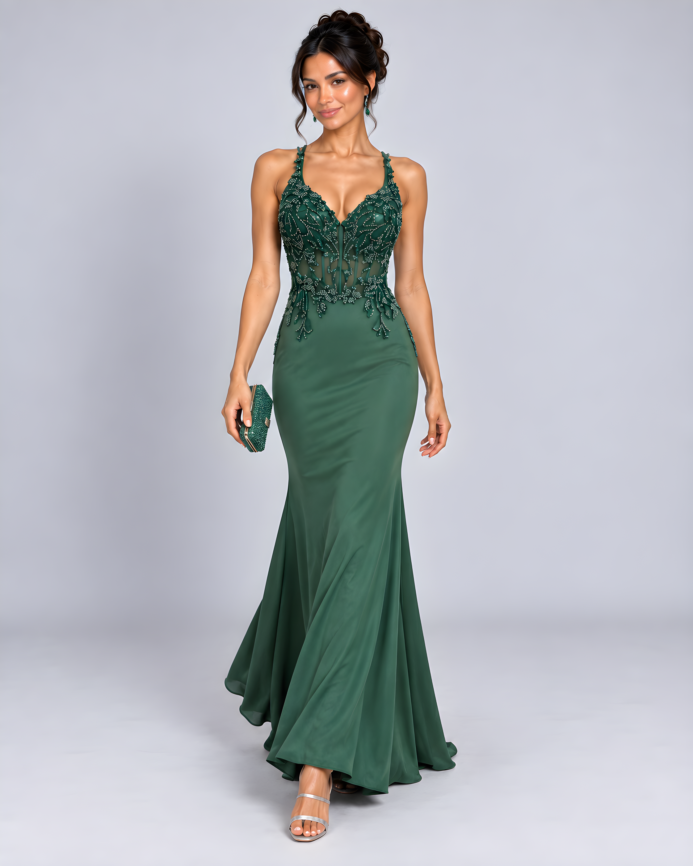Front view of model showing Emerald green fitted evening gown with a beaded sheer corset bodice and criss-cross back