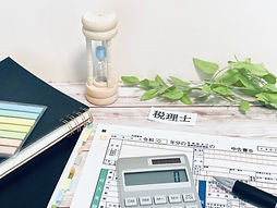 色々な資料の乗った税理士の机