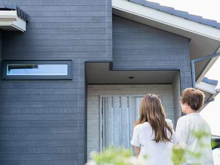 家を眺める夫婦