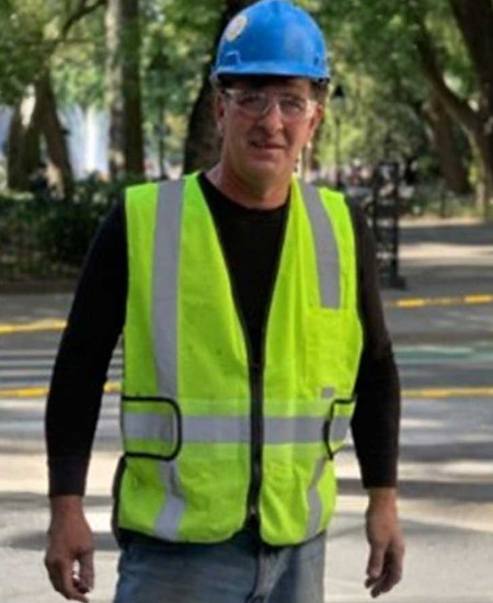 Team member in a blue hard hat and safety vest.