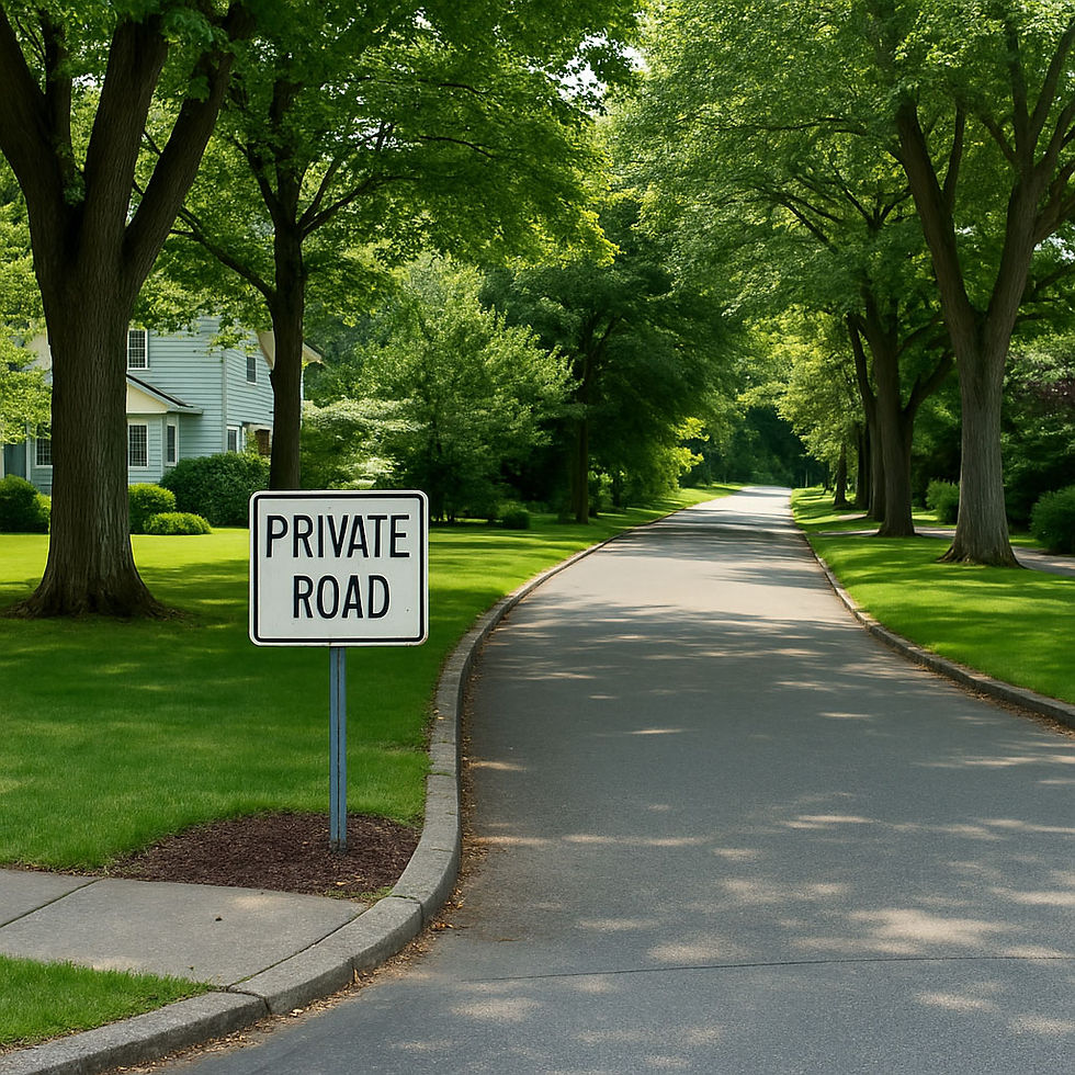 A tree-lined road with a "Private Road" sign, bordered by lush greenery and a house on the left, under a clear blue sky.