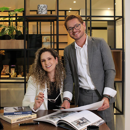 Foto dos socios do escritório analisando um projeto de arquitetura