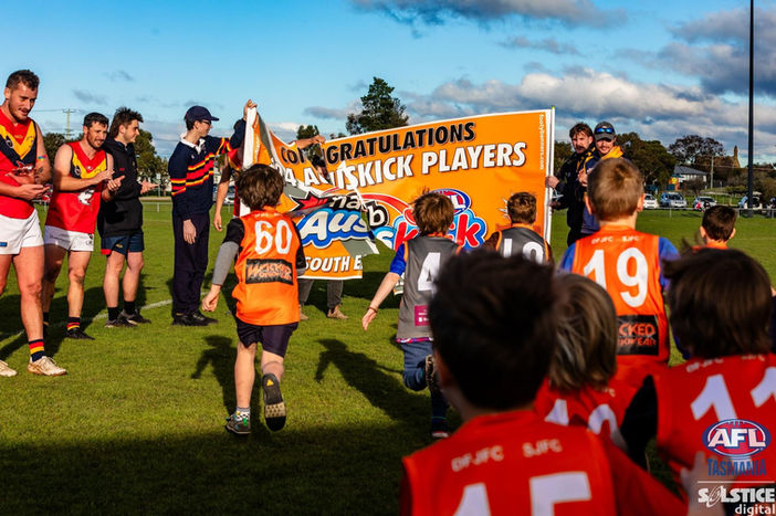 Grand final crowd showcasing banners with team chants and slogans