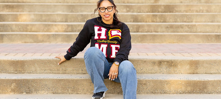 Female model sitting on steps wearing HOME Sweatshirt