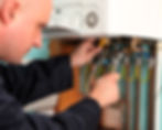 engineer tweaking boiler pipes