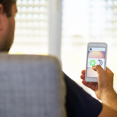 person controlling blinds with an app on his phone