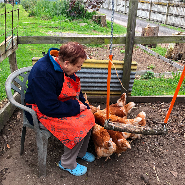 A visitor sitting down to feed the chickens