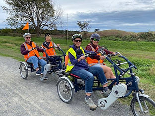 Two visitors and volunteers enjoying the duo-bike and trailer