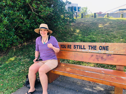 A visitor sitting on a bench reading "You're still the one"
