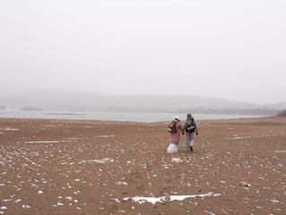 A Colorado bride and groom hiking on the beach at Sapphire Point in Dillon, CO