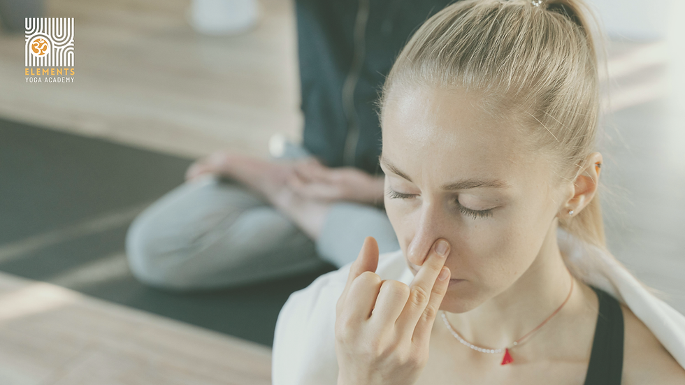 Woman practicing deep breathing in yoga class, eyes closed, serene setting. Background shows seated person. Logo: Elements Yoga Academy.
