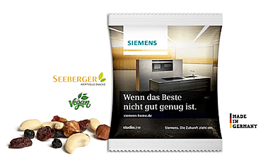 Handvoll Seeberger Nüsse im Werbetütchen mit Firmenlogo