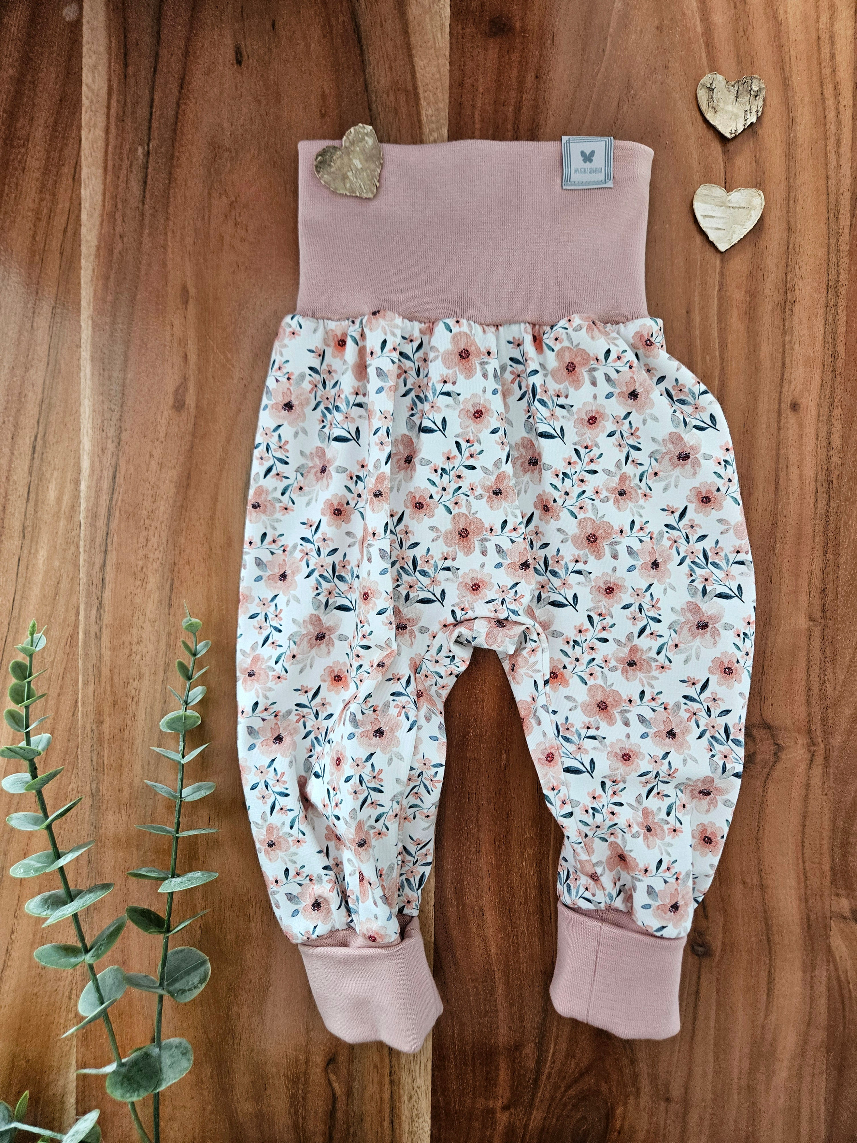 Lange-Pumphose-mitwachsend-rosa-Blumen-auf-creme-Hintergrund