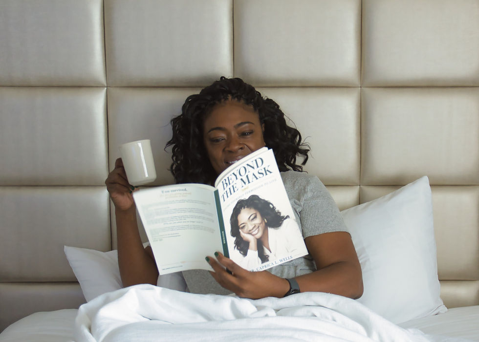 Dr. Caprica Wells sitting in bed with coffee and reading Beyond the Mask.