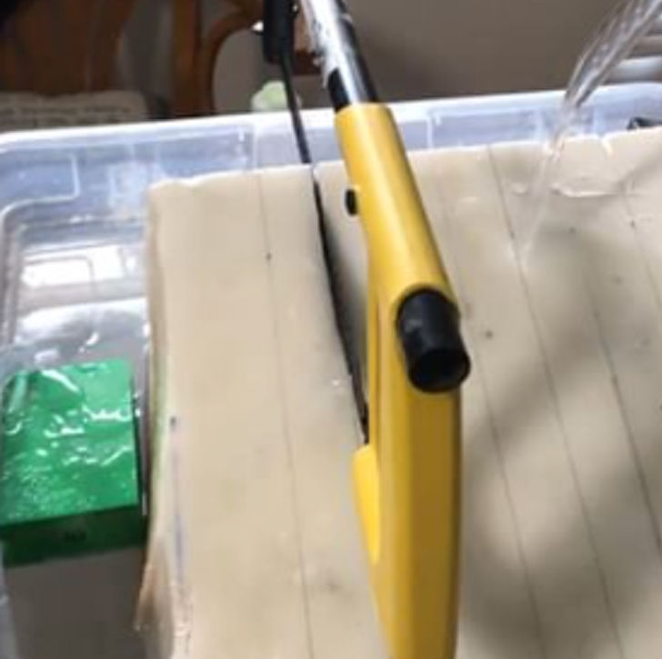 Hand sawing the rock with my saw while I run water over it