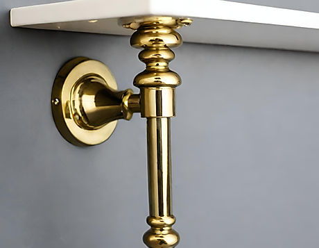 A close-up of a modern, hand-forged brass wall shelf bracket from Craftacks, featuring a distinct industrial design.