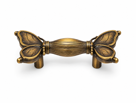 Craftacks exclusive antique brass cabinet pull handle with sculpted butterfly leaf mounts and reeded center bar isolated on a clean white background.