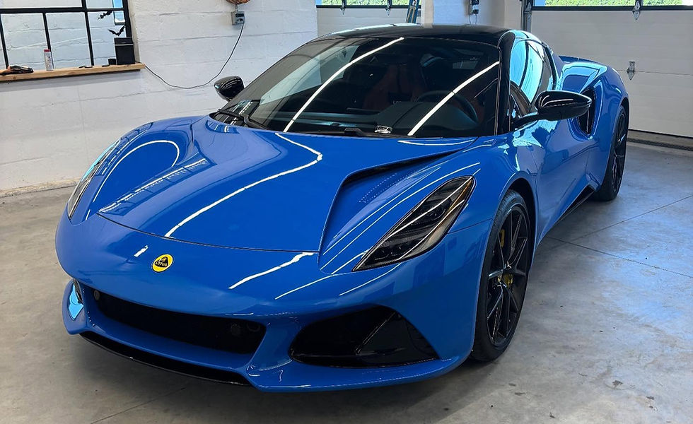 Blue Lotus sports car with black roof in a garage. Reflective lights accentuate its sleek design in Aaron's AutoGlass for windshield replacement.