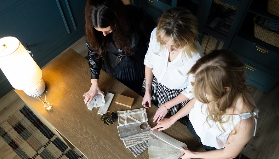 Glass House Collective designers arranging a living room set up, showcasing personalized home furnishings services.