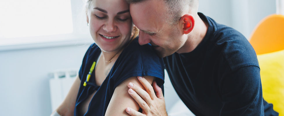Woman in labour with her birth partner stroking her arms.jpg