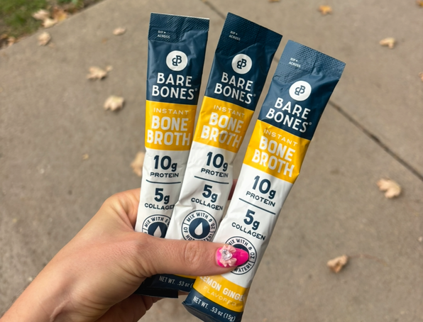 pink nails holding bone broth from bare bones chicken flavored