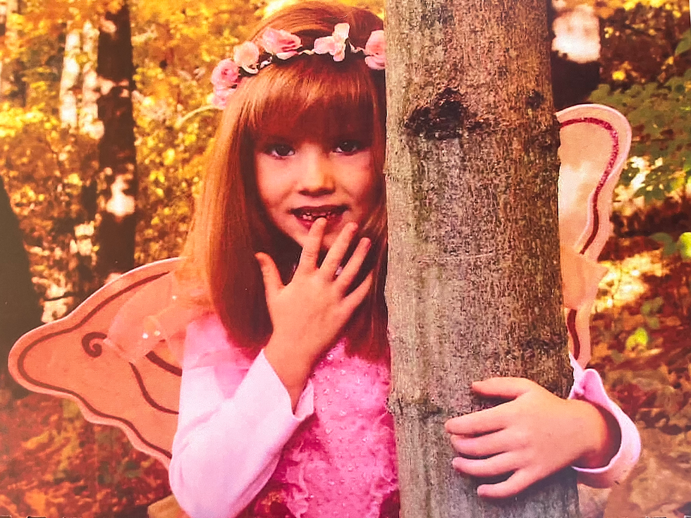 3 year old girl in pink magic princess fairy halloween costume by a tree