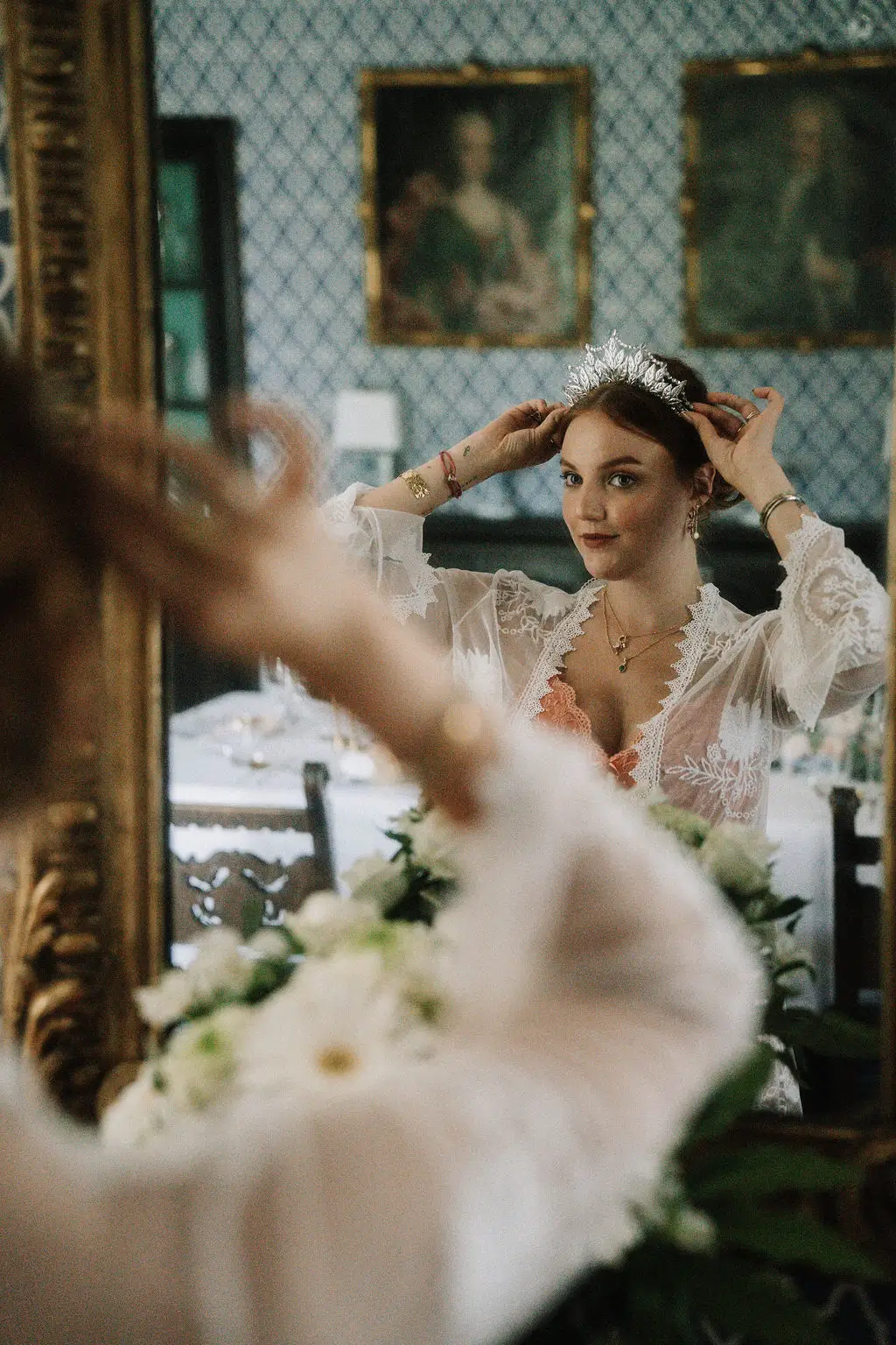 Braut mit Diadem und Spitzenumhang im Spiegel