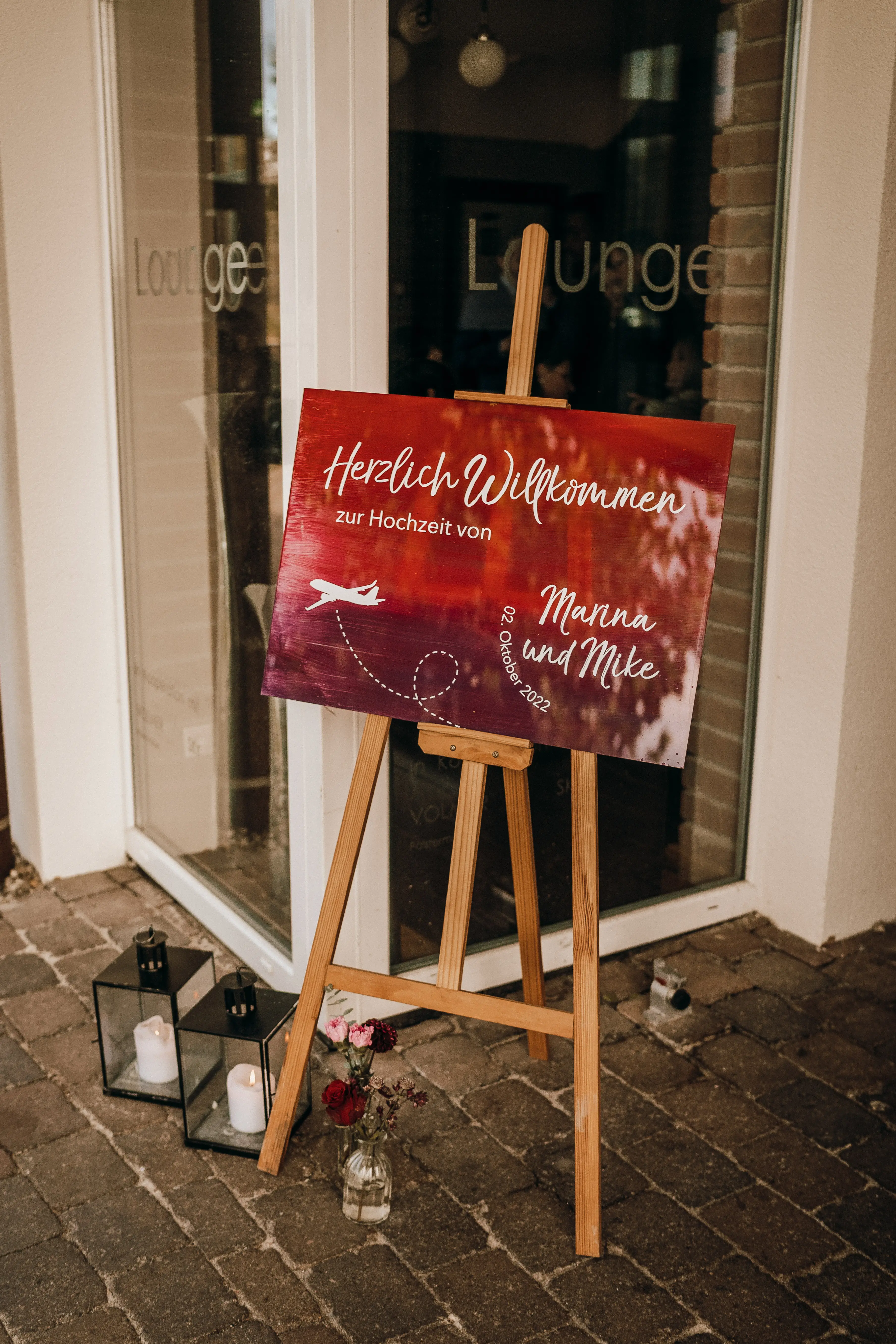 Willkommensschild für Hochzeit mit Reisethema in Beerentönen