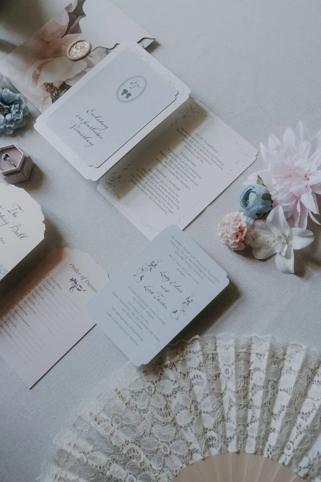 Pastellfarbene Hochzeitseinladung mit Wappen und floralen Details