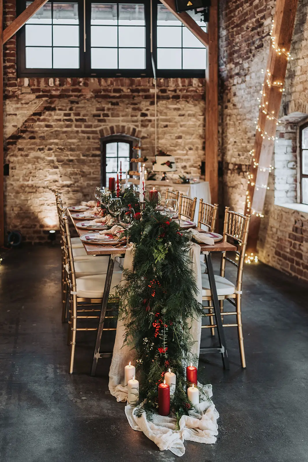 Hochzeitspaar Winterhochzeit in grün und rot mit Stabkerzen und goldenen Stühlen
