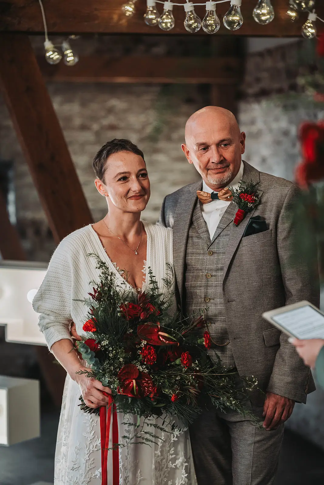 Eheversprechen Winterhochzeit Hochzeitspaar mit Brautstrauß rot grün