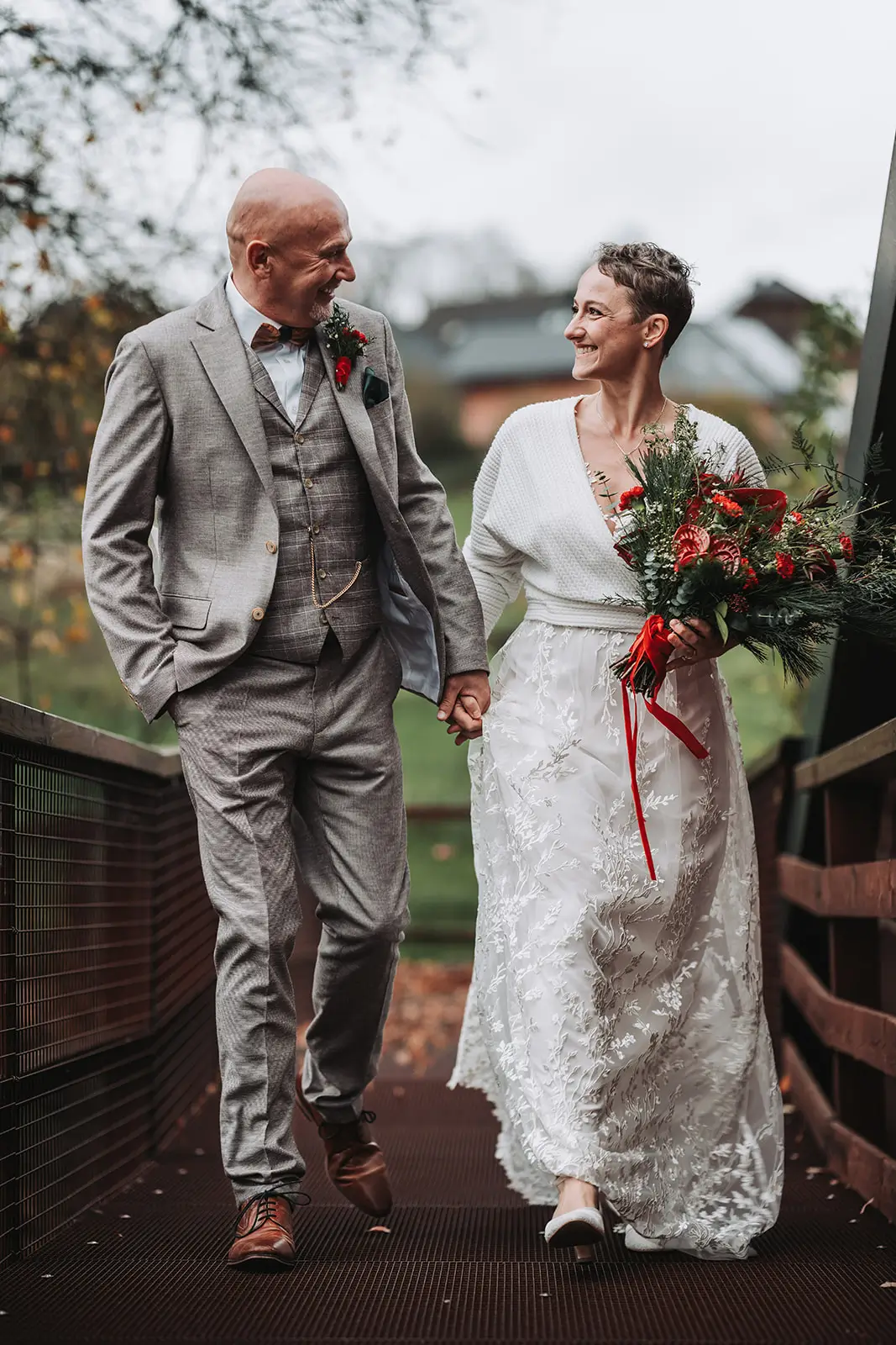 Hochzeitspaar Winterhochzeit mit Brautstrauß rot grün und handgefertigtem Kleid