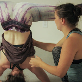 circus instructor teaches a student in handstand class at island circus space