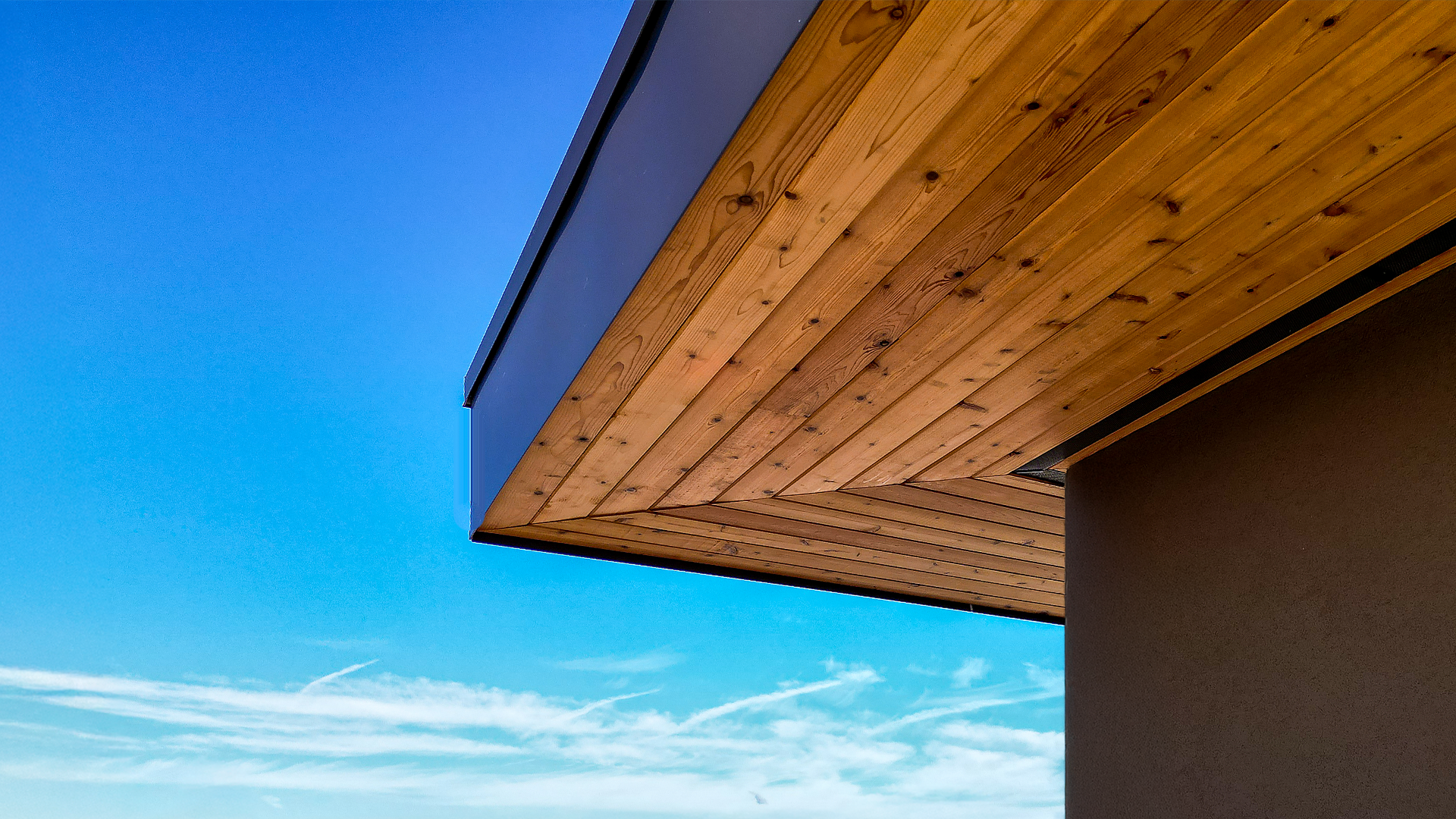Mid-day aerial photo showing the stained cedar 1x6 tight knot tongue and groove product used in the parapet enclosed soffit (outdoor ceiling application) of Building 3. Commercial storefront property waterproofing, siding, flashing & soffit installation by StraightLine Exteriors in Camas, Washington 98607. 