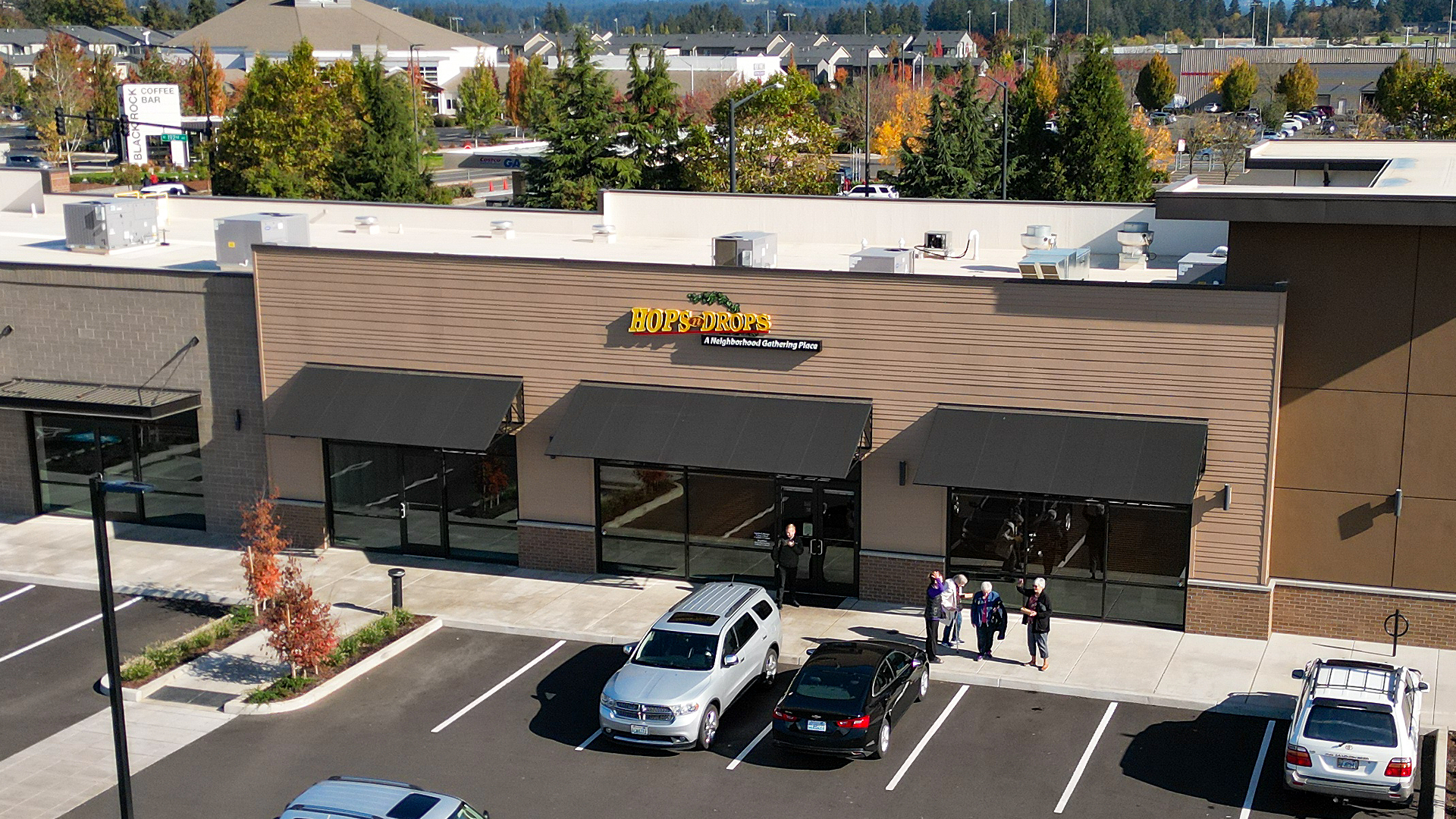 Mid-day aerial photo showing the front corner exterior elevation of Building 6. Installed products include James Hardie® Building Products fiber cement siding of HardiePlank in Select Cedarmill with a staggered reveal of 8in / 4in / 4in / 8 in reveal. Commercial storefront property waterproofing, siding, flashing & soffit installation by StraightLine Exteriors in Camas, Washington 98607. 