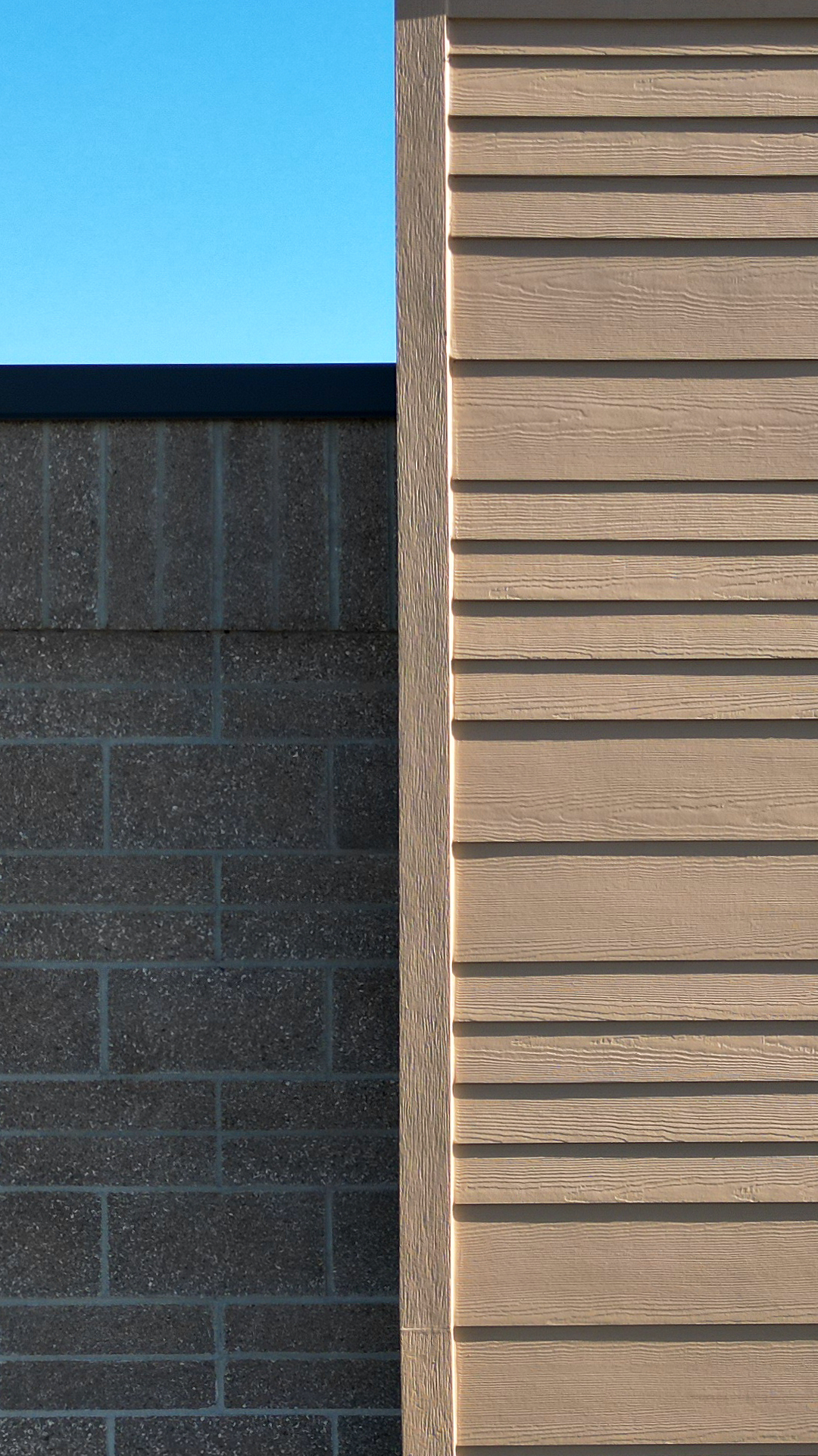 Close-up product photo showing the James Hardie® Building Products fiber cement siding of HardiePlank in Select Cedarmill with a staggered reveal of 8in / 4in / 4in / 8 in reveal on Buildings 3, 4, 5 & 6 of Lacamas Square. Commercial storefront property waterproofing, siding, flashing & soffit installation by StraightLine Exteriors in Camas, Washington 98607. 