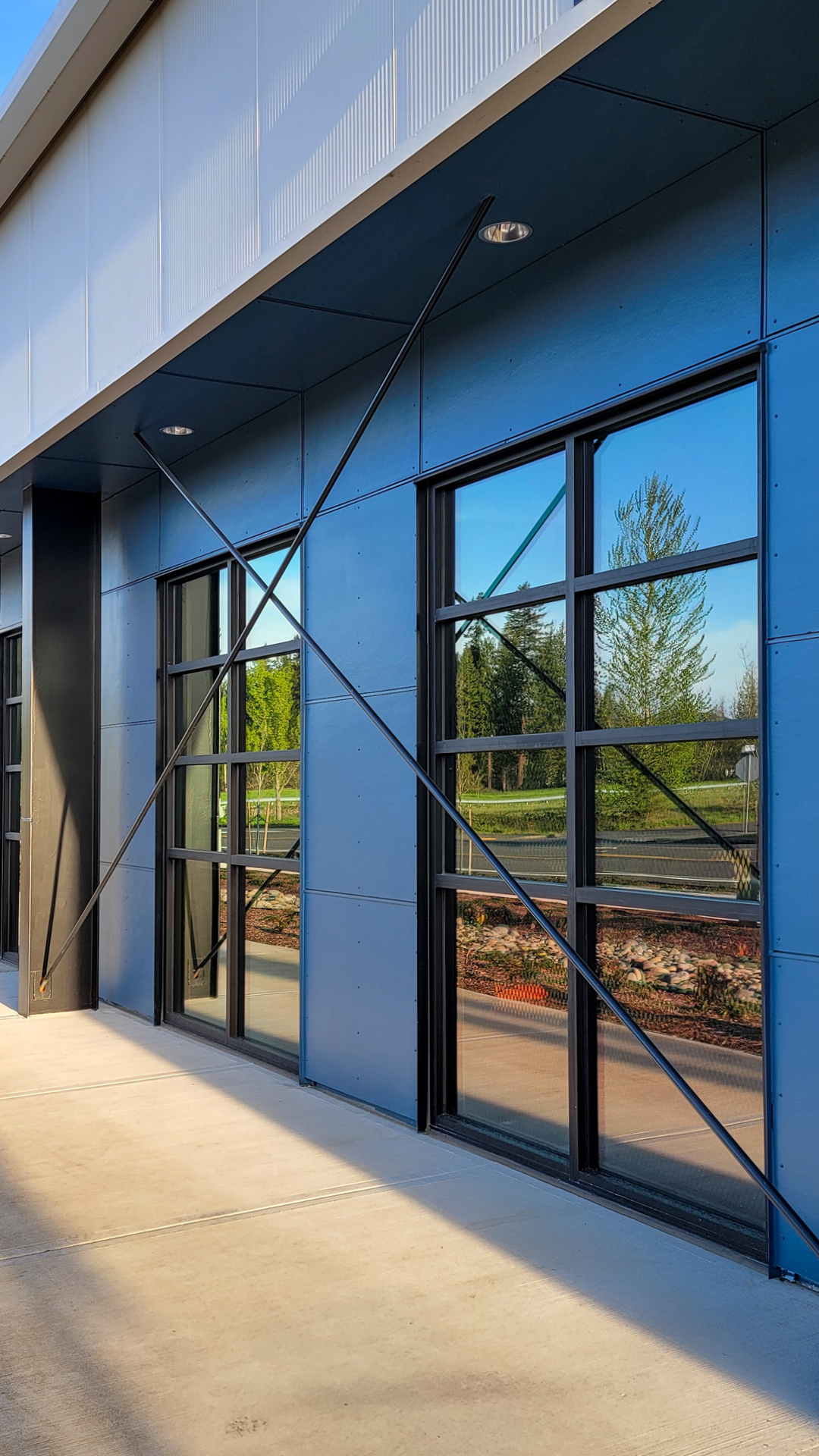 Mid day ground level photograph showing the new Northwest Line Joint Apprenticeship Training Facility (JATC) exterior design and office & classroom exterior elevation. Installed products include James Hardie fiber cement siding Architectural Collection Panels in the texture Fine Sand installed using Tamlyn Architectural Trim & Channel and exposed fasteners. This product was installed by StraightLine Exteriors in Battle Ground, Washington 98604. 