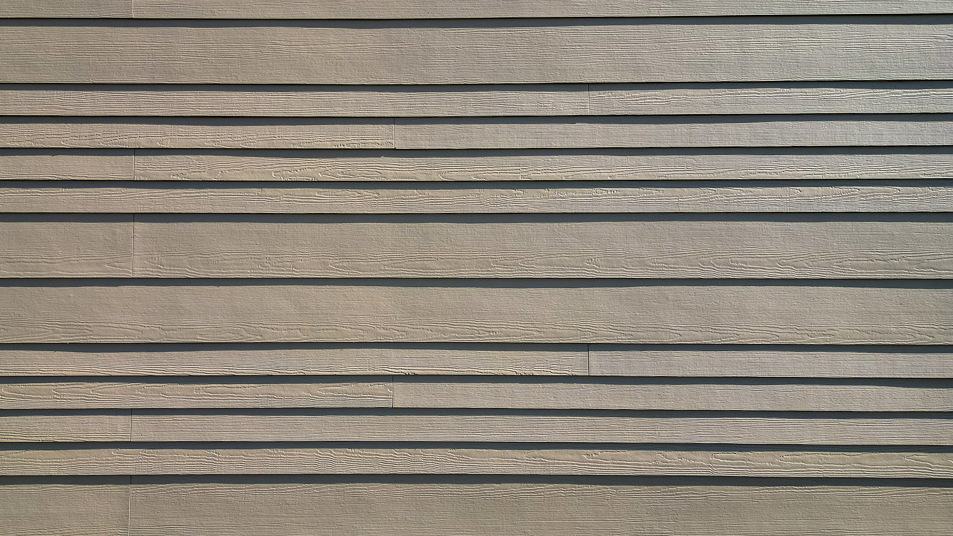Large, close-up product photo showing the James Hardie® Building Products fiber cement siding of HardiePlank in Select Cedarmill with a staggered reveal of 8in / 4in / 4in / 8 in reveal on Buildings 3, 4, 5 & 6 of Lacamas Square. Commercial storefront property waterproofing, siding, flashing & soffit installation by StraightLine Exteriors in Camas, Washington 98607. 